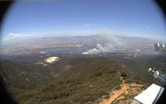 A bounding-box annotation from the dataset showing labeled wildfire smoke against a daytime sky.